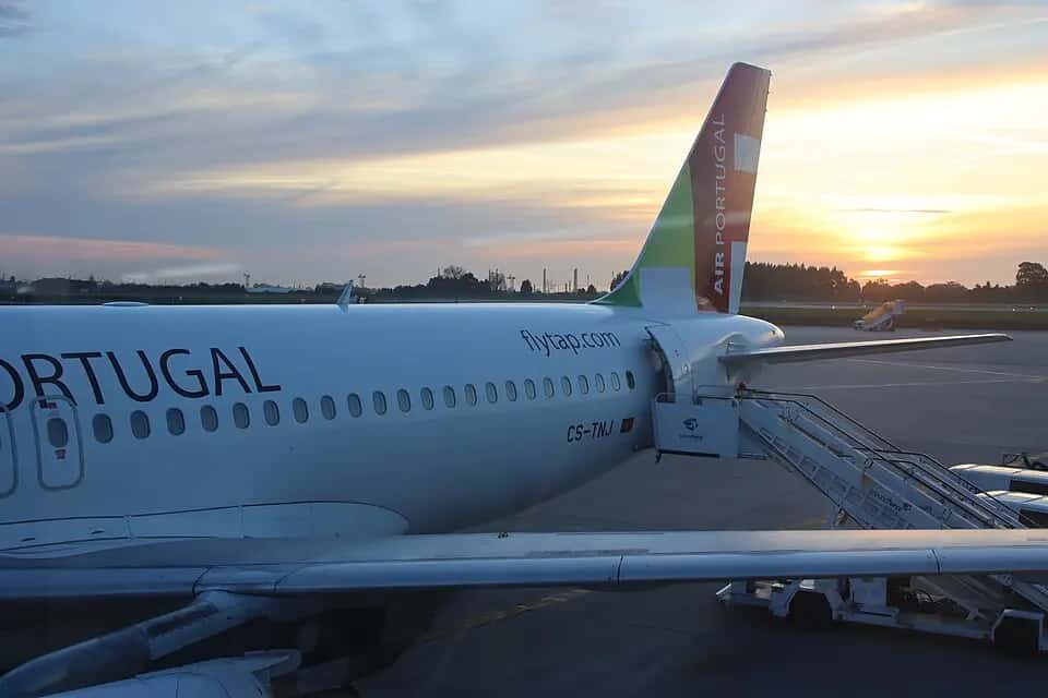 Letoun TAP Air Portugal u terminálu letiště Porto při západu slunce